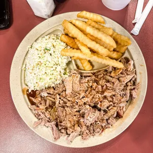 a plate of pulled pork, coleslaw and fries