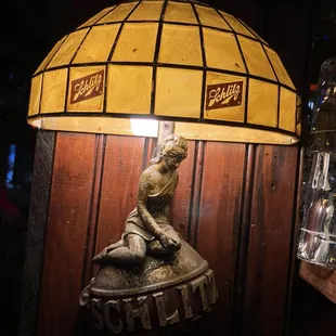 a statue of a woman sitting under a lamp