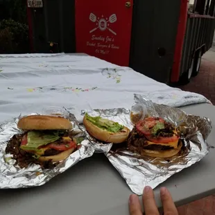 two burgers on aluminum foil