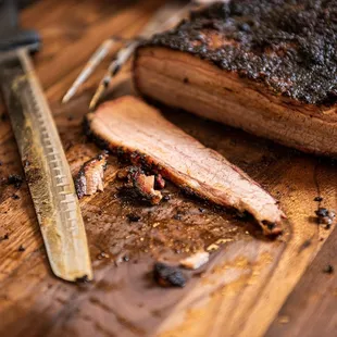 a piece of meat on a cutting board with a knife