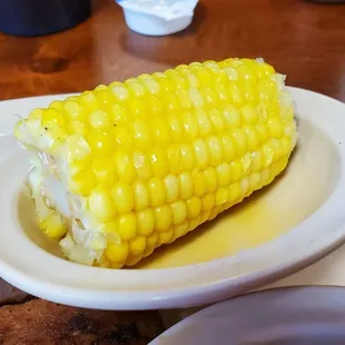 ows a corn on the cob with a side of bread