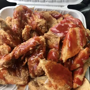 chicken wings and chips in a styrofoam container