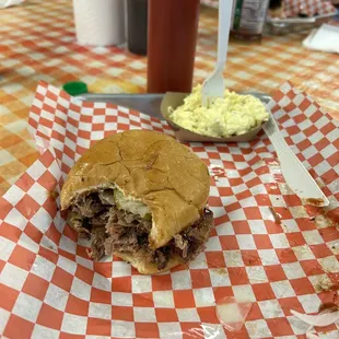 Brisket sandwich with pickles and onions. Plus side of potato salad.