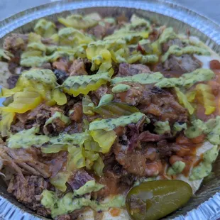 Nachos woth briket amd pork, beans and queso.