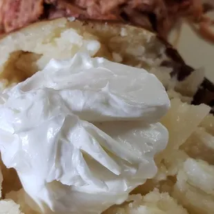 Baked tater with a large BBQ sandwich