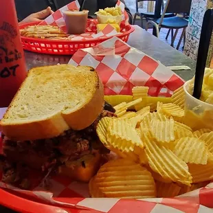 Brisket sandwich with chips and potato salad