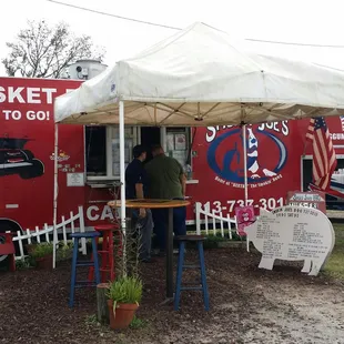 a man and woman standing under a tent
