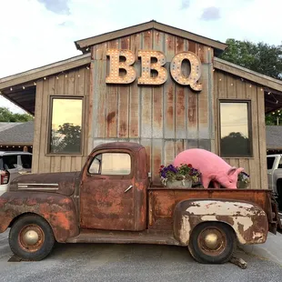 an old rusty truck with a sign that says bbq