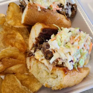 a pulled pork sandwich and potato chips