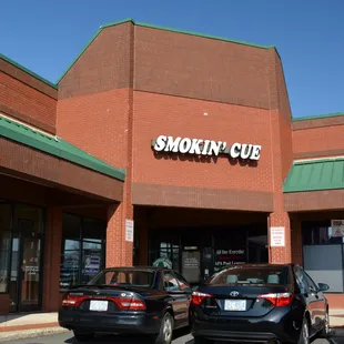 two cars parked in front of a store
