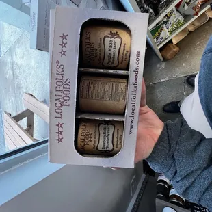 a person holding a box of beer