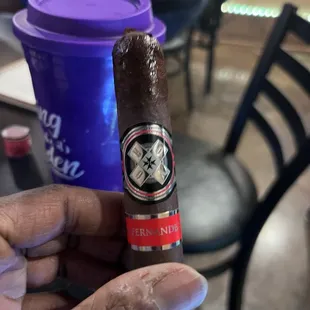 a hand holding a cigar