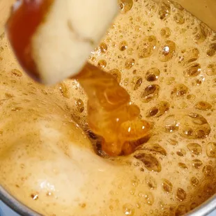 a hand dipping a piece of bread into a cup of coffee