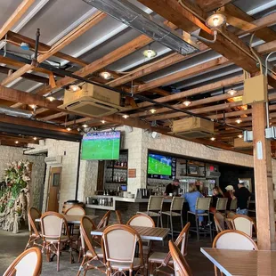 a restaurant with tables, chairs, and televisions