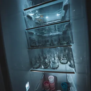 n open refrigerator filled with empty glasses