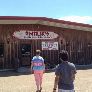 two people walking in front of a restaurant