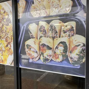 a display of sandwiches and pizzas