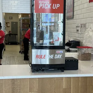 a woman standing at a counter in a fast food restaurant