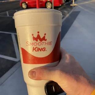 a hand holding a smoothie cup