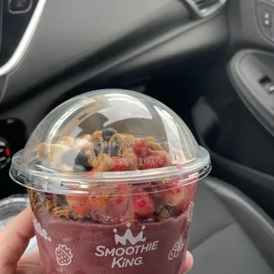 a hand holding a cup of smoothie