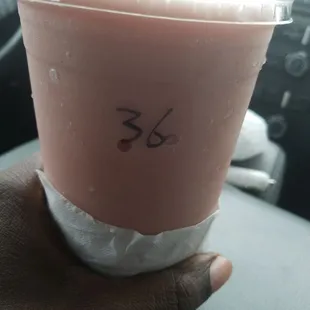 a hand holding a cup of smoothie