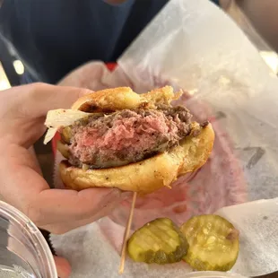a person holding a hamburger