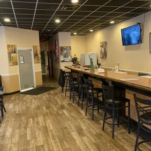 a bar with chairs and a television