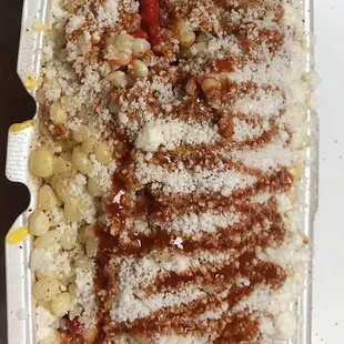 Nacho cheese on bottom, Hot Cheetos with Valentina sauce followed by a layer of corn with powder cheese and more Valentina on top.