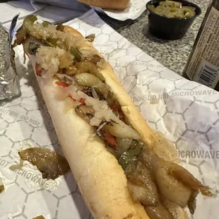 Footlong dog with grilled onions and peppers and sauerkraut