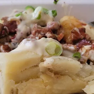 Brisket Texas Taters with queso and green onions.