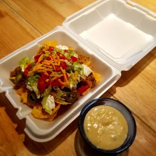 Beef Nachos with lettuce, tomatoes, jalapenos, cheddar cheese &amp; side of Queso