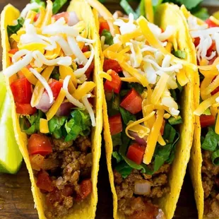 three tacos on a cutting board