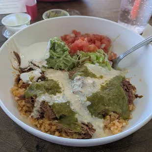 Shredded beef burrito bowl with guacamole and sour cream.