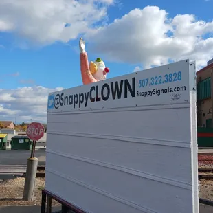 a stop sign with a clown on top
