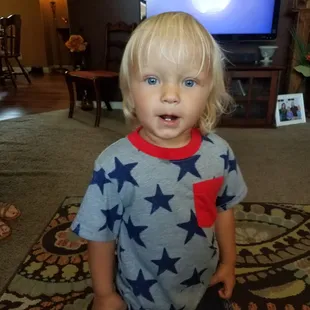 a toddler standing in front of a television