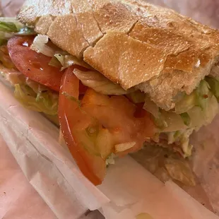 a sandwich with tomatoes and lettuce
