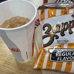 a cup of soda and a bag of chips