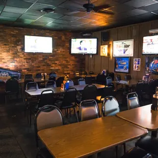 tables and chairs with televisions in the background
