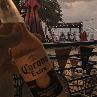 a person holding a bottle of corona extra