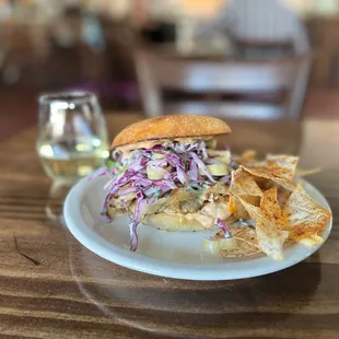 a pulled pork sandwich with cole slaw and chips