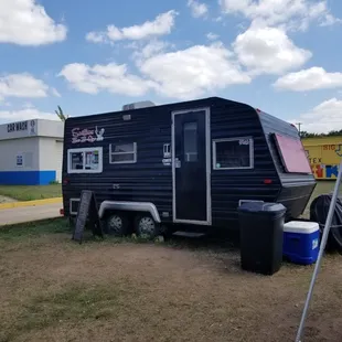 a black trailer parked in a field