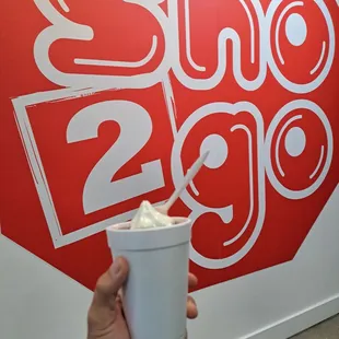 a hand holding a cup of ice cream