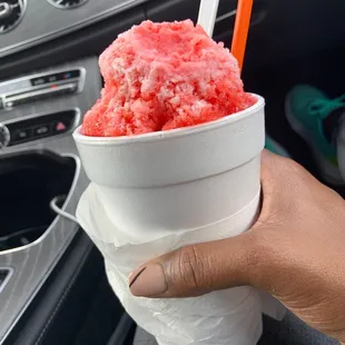 a hand holding a cup of ice cream