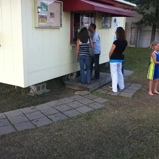 a group of people standing outside of a mobile home