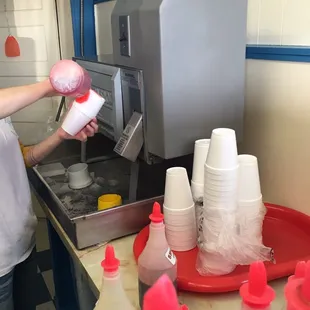 She's making the yummy Sno-cones super fast!