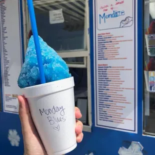 a person holding a cup of blue ice