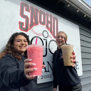 two women holding up drinks