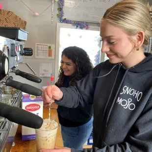 a woman filling a cup of coffee