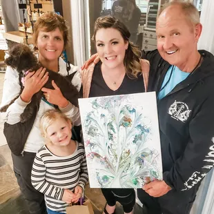 a family holding a painting