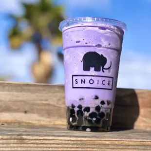 a cup of bubble tea on a wooden table